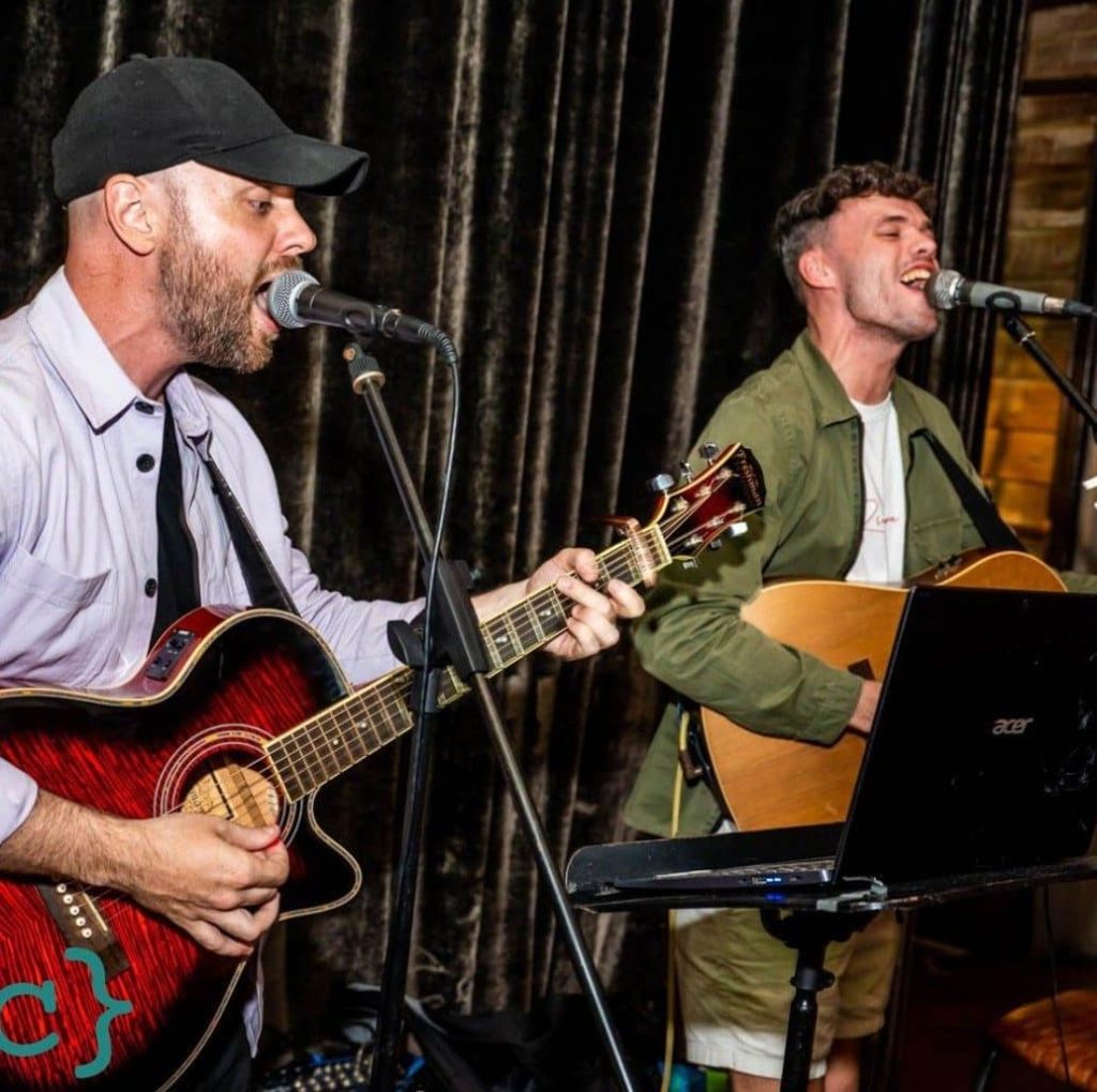 Two singers playing guitar