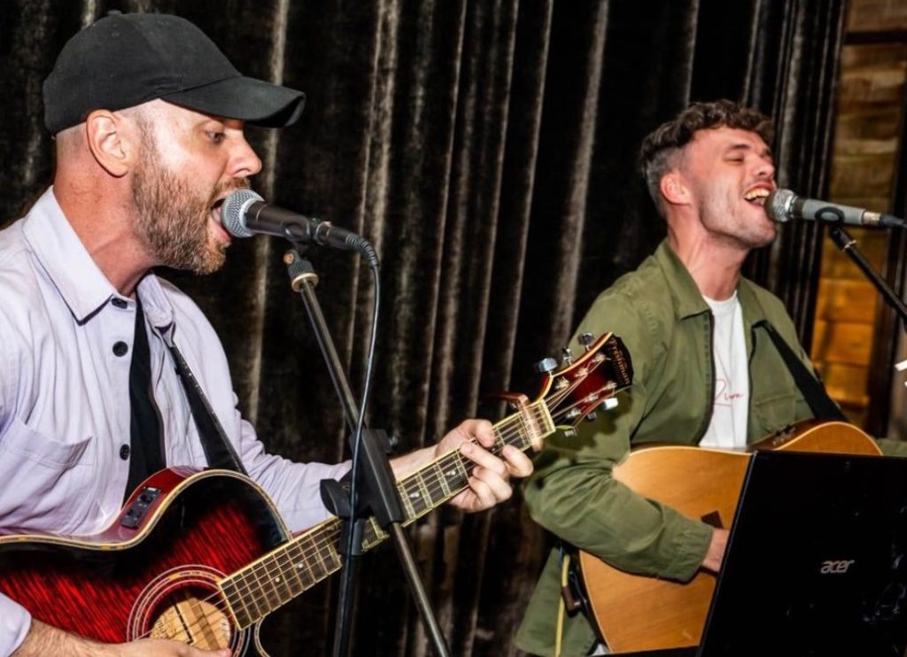 Two singers playing guitar